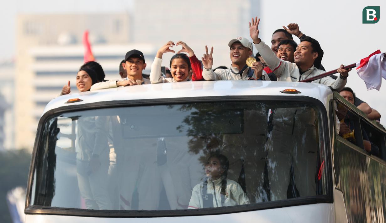 Sejumlah atlet dan ofisial Kontingen Indonesia pada Olimpiade Paris 2024, termasuk peraih medali emas, Veddriq Leonardo dan Rizki Juniansyah serta peraih medali perunggu, Gregoria Mariska Tunjung mengikuti pawai dengan menaiki bus tingkat terbuka Transjakarta menuju Istana Negara, Jakarta Pusat, Kamis (15/8/2024). (Bola.com/Abdul Aziz)
