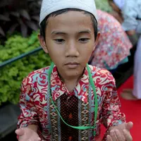 Seorang anak yatim terlihat berdoa usai mengambil air wudhu, Jakarta, Kamis (18/6/2015). Jokowi mengundang 400 anak yatim dari 12 panti asuhan yang ada di Jabodetabek untuk berbuka puasa bersama di Isatana Negara (Liputan6.com/Faizal Fanani)
