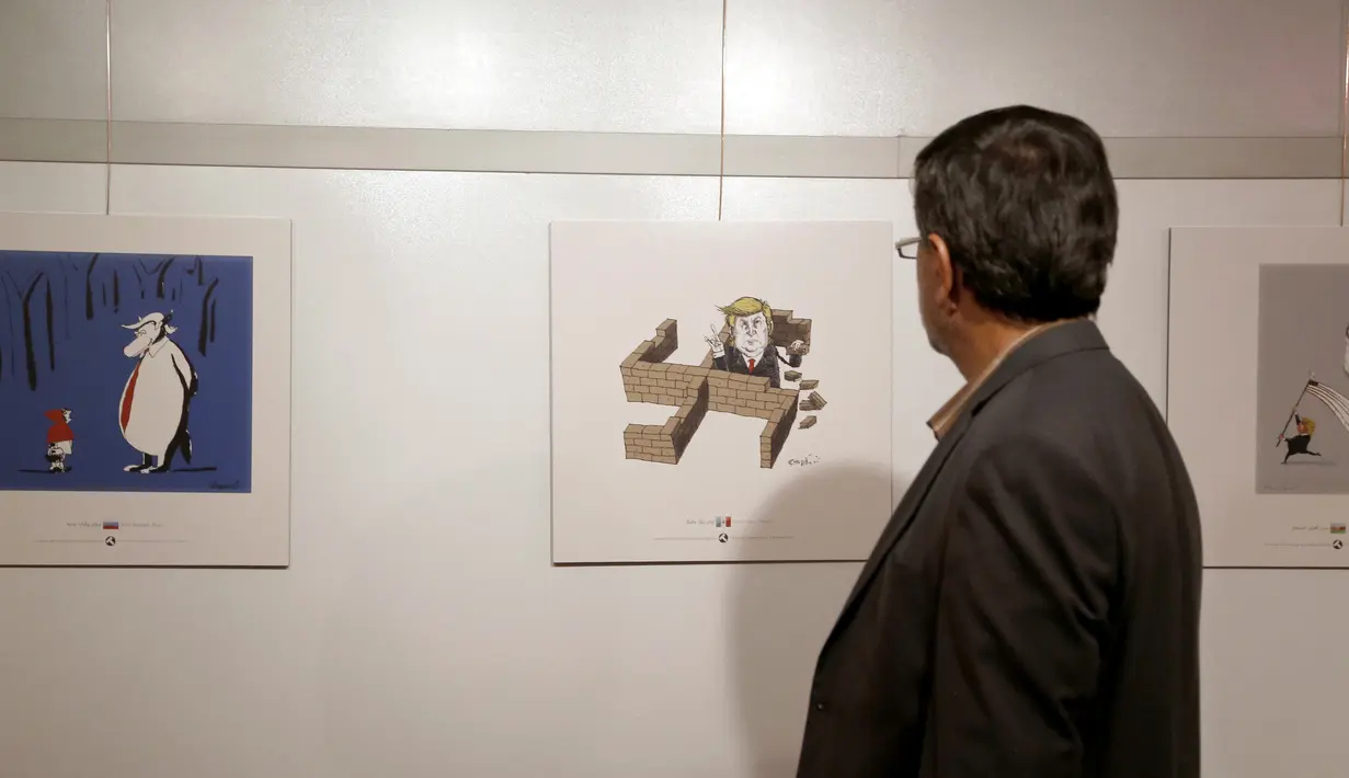 Pengunjung melihat kartun Presiden AS Donald J. Trump di sebuah pameran kartun Trumpisme 2017 Internasional dan kontes karikatur, di ibukota Teheran, Iran (3/7). (AFP Photo/Atta Kenare)