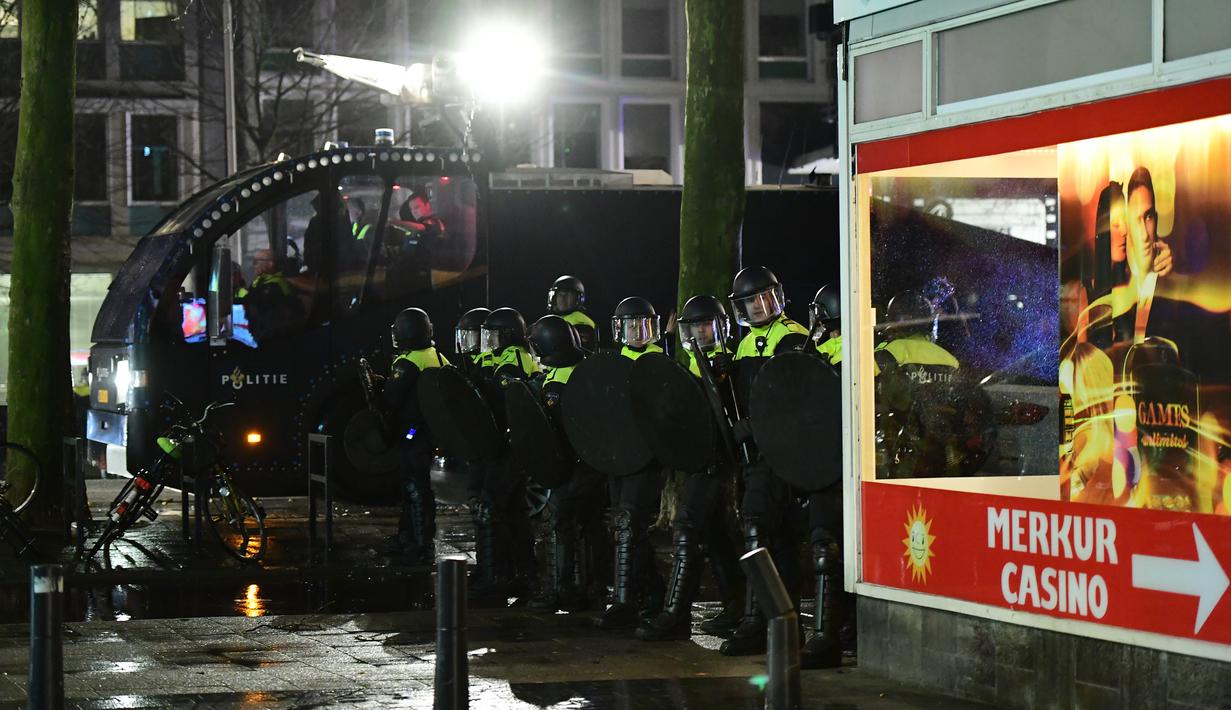 Polisi bersiap untuk mengamankan aksi protes yang digelar oleh warga Turki di Rotterdam, Belanda (11/3). Ketegangan ini terjadi beberapa jam setelah Mevlut Cavusoglu menyatakan akan terbang ke Rotterdam dan dilarang Belanda. (AFP/Emmanuel Dunand)