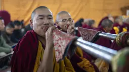 Biksu Buddha Tibet di pengasingan meniup terompet upacara selama sesi doa pagi untuk menyambut Tahun Kelinci Air di Dharamshala, India, Selasa (21/2/2023). Dalam penanggalan tradisional Tibet setiap tahun memiliki binatang, unsur, dan angka. (AP Photo/Ashwini Bhatia)