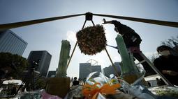 Anggota staf merawat altar darurat untuk berkabung bagi korban gempa bumi dan tsunami 11 Maret 2011 dalam acara peringatan khusus di Tokyo, Jumat (11/3/2022). Jepang menandai peringatan 11 tahun gempa bumi, tsunami dan bencana nuklir yang melanda pantai timur laut Jepang. (AP Photo/Eugene Hoshiko)