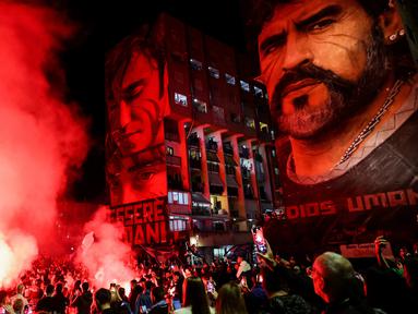 Fans merayakan ulang tahun Diego Maradona di bawah mural legenda sepak bola itu di Distrik San Giovanni, Napoli, Italia, 30 Oktober 2022. Legenda sepak bola asal Argentina, Diego Armando Maradona yang lahir pada 30 Oktober 1960 meninggal pada 25 November 2020. (Alessandro Garofalo/LaPresse via AP)