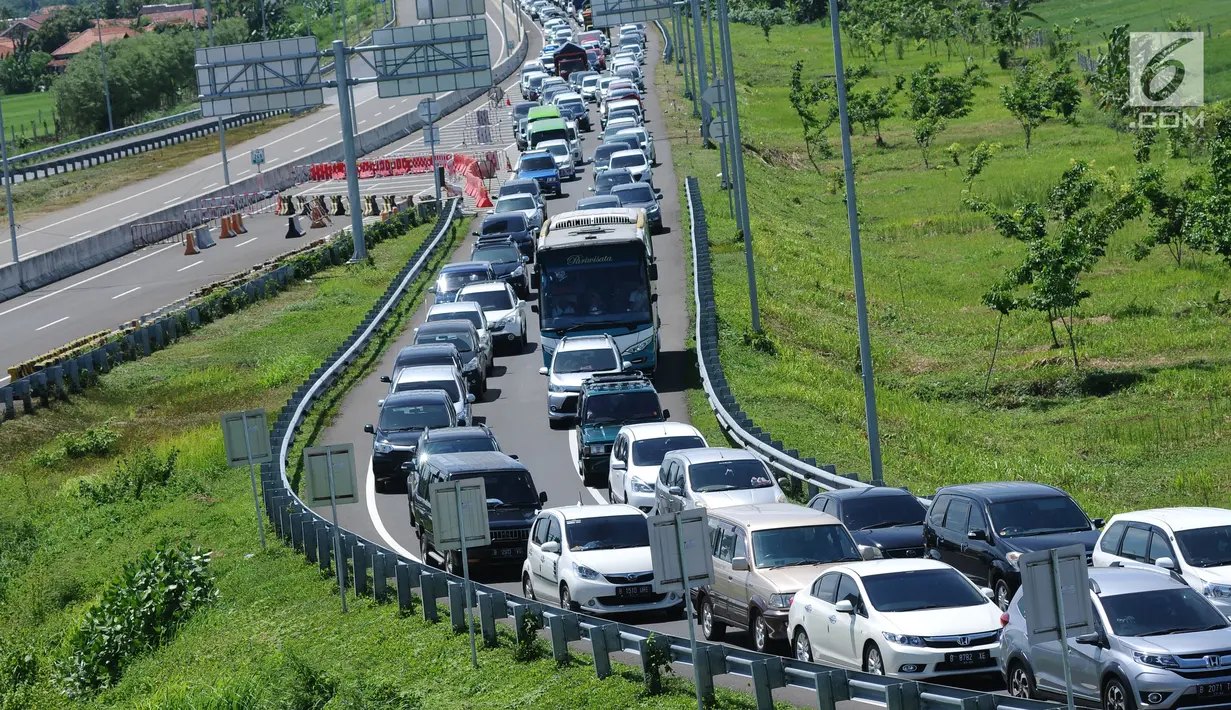 Kendaraan mengular antre menuju pintu keluar Tol Brebes Timur, Jawa Tengah, Sabtu (23/12). Libur Natal 2017, antrian kendaraan yang akan keluar dari pintu Tol Brebes Timur mencapai tiga kilometer. (Liputan6.com/Helmi Fithriansyah)