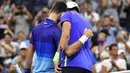 Petenis Serbia, Novak Djokovic (kiri) dan Matteo Berrettini dari Italia berpelukan setelah pertandingan perempat final AS Terbuka 2021 di Arthur Ashes Stadium, New York, Kamis (9/9/2021). Petenis nomor satu dunia, Novak Djokovic melaju ke semifinal setelah menang 5-7, 6-2, 6-2, 6-3. (Ed JONES/AFP)