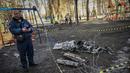 Seorang pria berdiri di samping sisa-sisa rudal di Kota Kharkiv, Ukraina timur, 24 Februari 2022. Angkatan bersenjata Rusia melancarkan invasi militer ke Ukraina. (Aris Messinis/AFP)