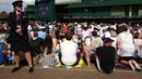 Petugas berjaga dekat ribuan penonton yang menyaksikan laga Andy Murray melawan Milos Raonic pada final tunggal putra  Wimbledon Championships 2016 di The All England Lawn Tennis Club,  Wimbledon, London, (10/7/2016).  (AFP/Justin Tallis)