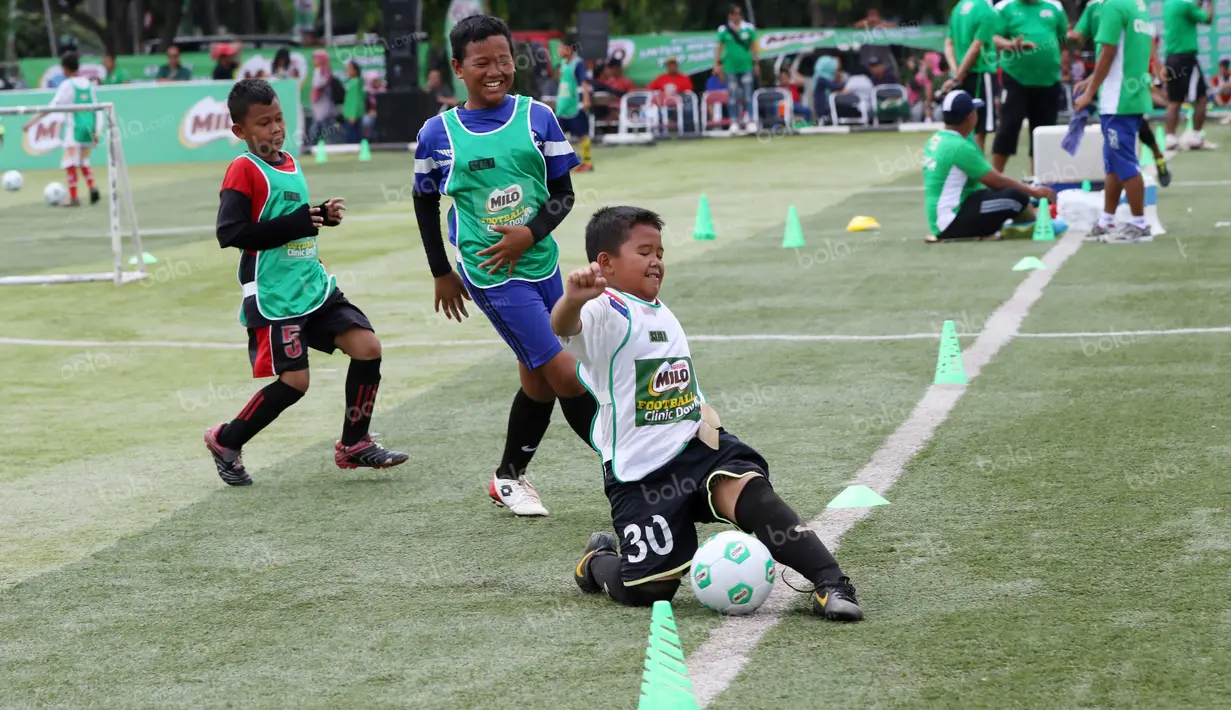 Layaknya pemain profesional, seorang anak berusaha menghalau bola yang keluar lapangan saat mengikuti Milo Football Clinic di Lapangan Sepak Bola Pertamina, Simprug, Jakarta, Minggu (24/4/2016). (Bola.com/Nicklas Hanoatubun)
