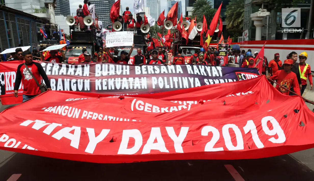 Peserta aksi dari sejumlah elemen buruh membentangkan poster dan spanduk aksi memperingati Hari Buruh Sedunia di kawasan Bundaran HI, Jakarta, Rabu (1/5/2019). Massa aksi dalam peringatan Hari Buruh 2019 tidak dapat mendekati Istana Merdeka lantaran tertahan di kawasan itu. (Liputan6.com/Johan Tallo
