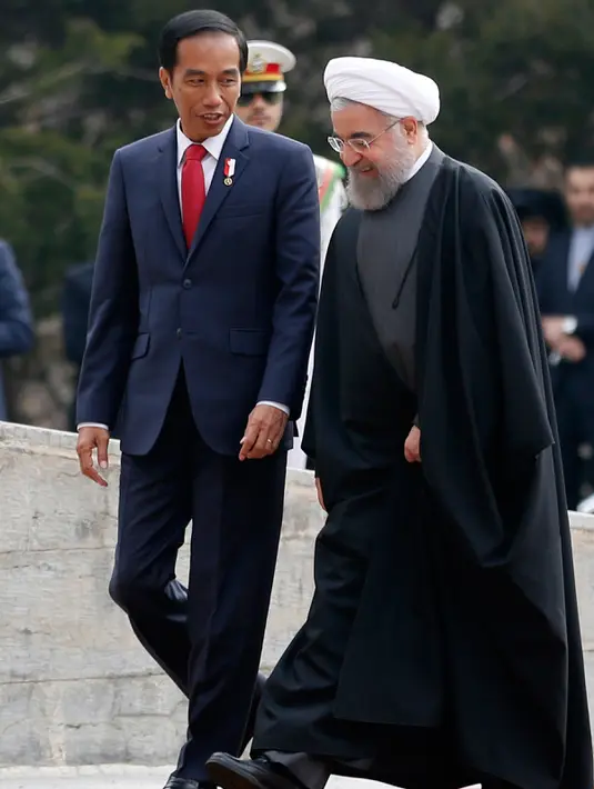 Presiden Joko Widodo berbincang dengan Presiden Hassan Rouhani di Istana Saadabad, Rabu (14/12). Dalam kunjungannya, Jokowi akan melakukan pertemuan bilateral, penandatanganan nota-nota kesepahaman. (AFP Photo/Atta Kenare) 