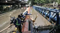 Petugas menggunakan pompa saat menyedot banjir yang menggenangi Jalan RE Martadinata, Ancol, Jakarta, Selasa (9/11/2021). Banjir mengakibatkan akses dari arah Jalan Gunung Sahari menuju Penjaringan ditutup sementara dan pengendara disarankan mencari jalan alternatif. (merdeka.com/Iqbal S. Nugroho)