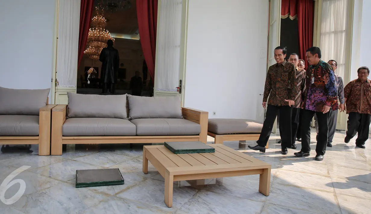 Presiden Joko Widodo (kiri) ditemani para pengurus untuk memulai proses pencetakan kaki dan tangannya di Istana Merdeka, Jakarta, Selasa (13/10/2015). Cetakan tersebut akan diletakkan di Taman Pintar Yogyakarta. (Liputan6.com/Faizal Fanani)   