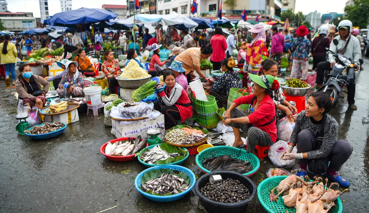 Pedagang memajang dagangannya saat mereka menunggu pelanggan di pasar di Phnom Penh (24/7/2020). Kota ini memiliki penduduk sekitar 1 juta jiwa, sementara seluruh penduduk Kamboja adalah 11,4 juta jiwa. . (AFP/Tang Chhin Sothy)