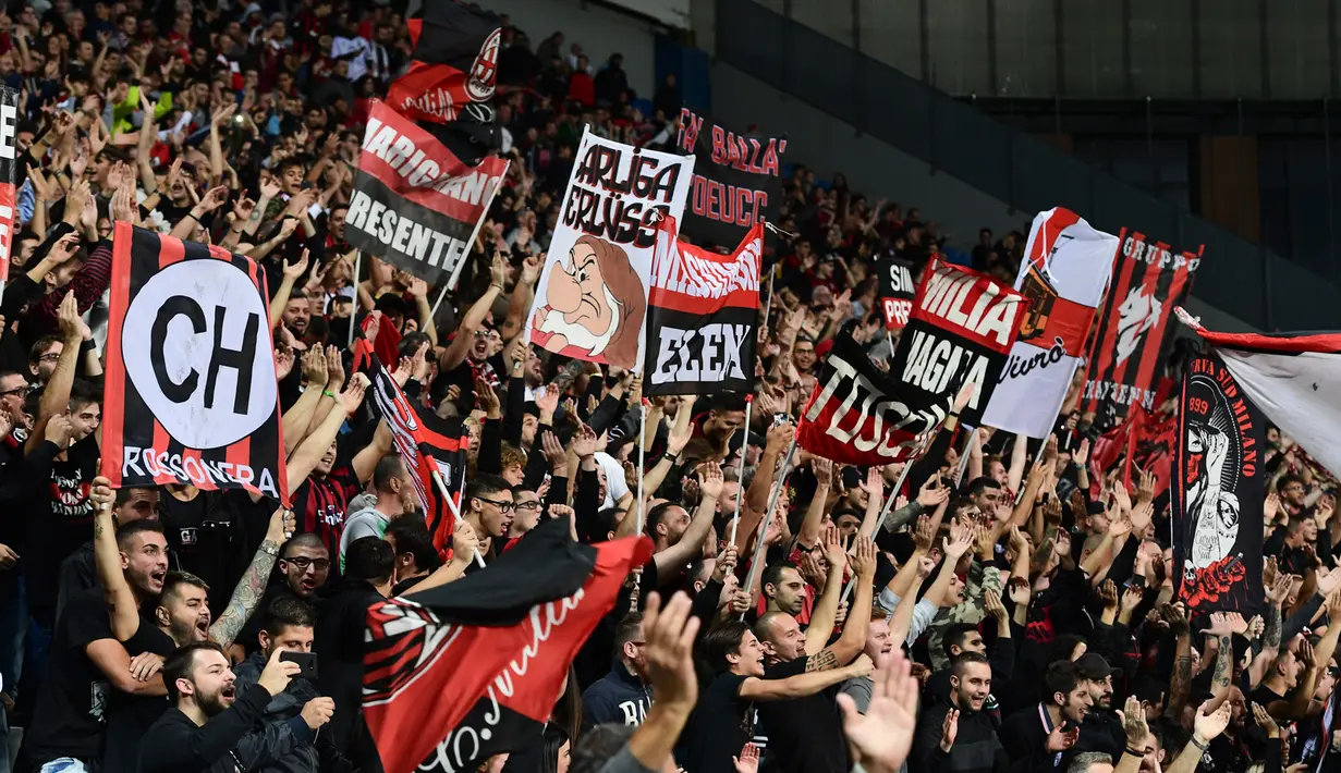Suporter AC Milan bersorak saat mendukung timnya bertanding melawan Sassuolo pada lanjutan Liga Italia di Stadion Mapei, Reggio Emilia (30/9). AC Milan menang telak 4-1 atas Sassuolo berkat gol Kessie, Suso dan Castillejo.  (AFP Photo/Miguel Medina)