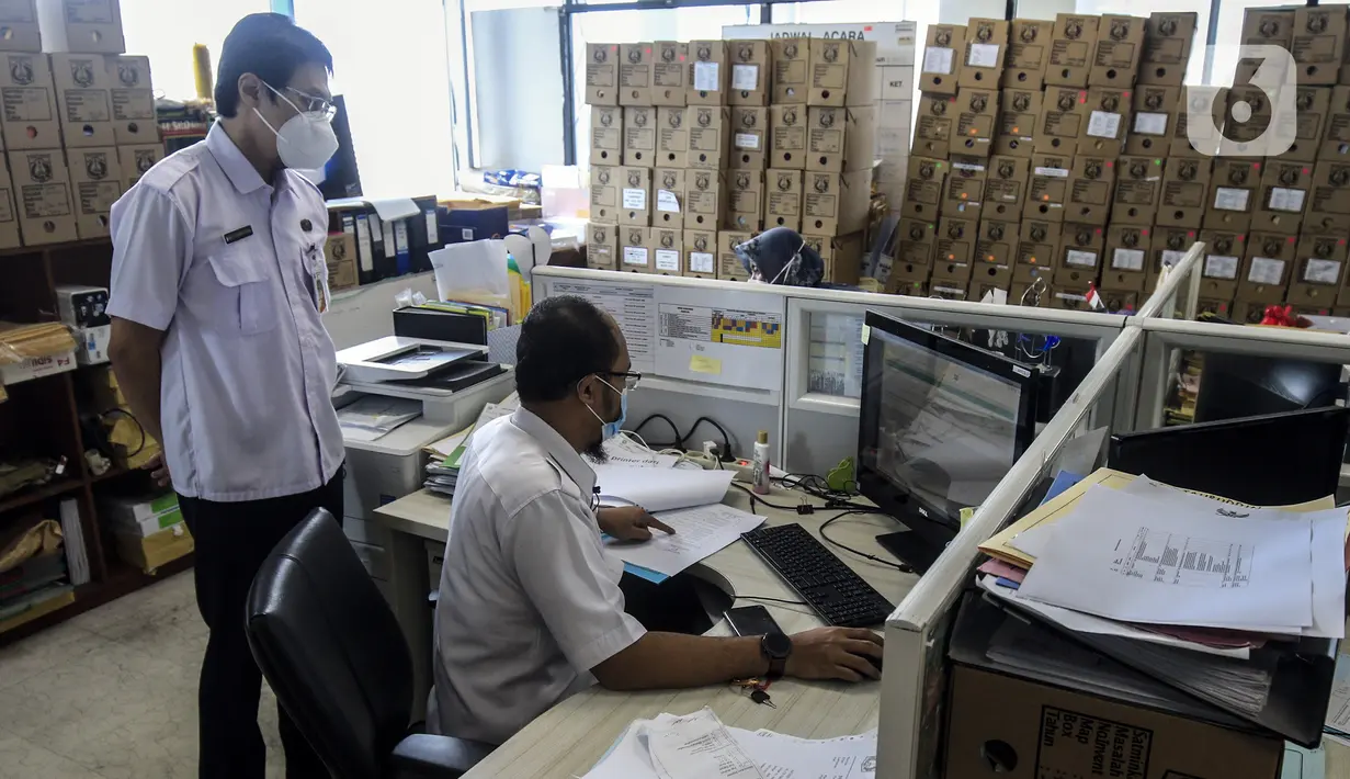 Pegawai Badan Kepegawaian Daerah DKI Jakarta menyelesaikan pekerjaannya di Kantor Balai Kota DKI Jakarta, Kamis (11/2/2021). Kementerian PANRB secara resmi melarang seluruh ASN bepergian ke luar kota saat libur Imlek guna mencegah penyebaran dan penularan COVID-19. (Liputan6.com/Johan Tallo)