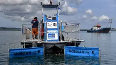 Kapal Mobula 8 membersihkan sampah di laut Pelabuhan Benoa, Denpasar, Bali, Selasa (21/3/2023). (SONNY TUMBELAKA/AFP)