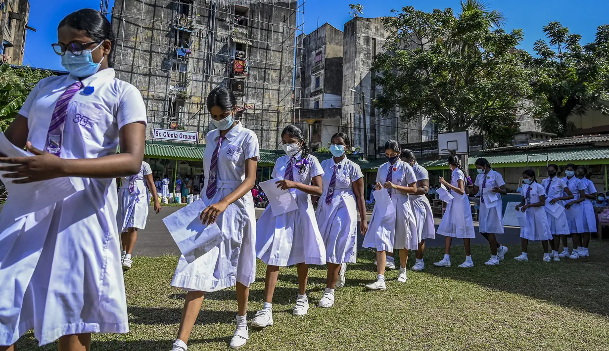 Para siswi kelompok usia 12-15 tahun mengantre untuk mendapatkan suntikan vaksin Pfizer-BioNTech terhadap virus corona Covid-19 di sebuah lembaga pendidikan di Kolombo, Sri Lanka (7/1/2022). (AFP/Ishara S. Kodikara)