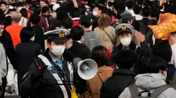 Polisi mendesak pejalan kaki dengan kostum untuk terus bergerak menyeberangi persimpangan jalan yang terkenal saat perayaan Halloween di distrik hiburan Shibuya, Tokyo, Jepang, 31 Oktober 2022. Polisi juga berjaga di jalan untuk mengantisipasi kerumunan besar dan mengingatkan warga agar mematuhi protokol kesehatan agar tidak menimbulkan kasus baru COVID-19. (AP Photo/Hiro Komae)