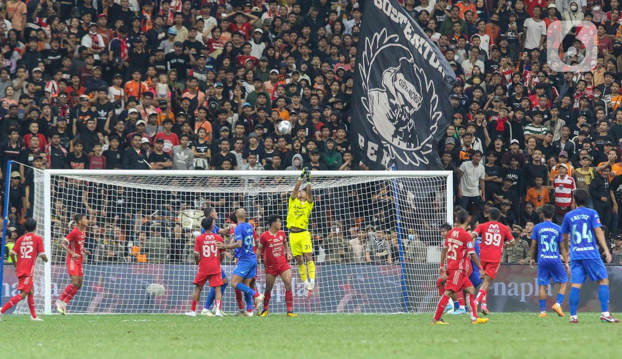 Kiper Persija Jakarta Adre Arido menipis bola  pada laga persahabatan melawan Chonburi FC dalam rangka peresmian Stadion Jakarta International Stadium (JIS) di Jakarta, Minggu (24/7/2022). Pertandingan berakhir imbang dengan skor 3-3. (Liputan6.com/Herman Zakharia)