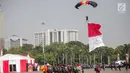 Penerjun payung bersiap mendarat saat tampil dalam perayaan HUT ke-73 Bhayangkara di Monas, Jakarta, Rabu (10/7/2019). Sebanyak 22 penerjun payung dari TNI dan Polri ikut menyemarakkan HUT ke-73 Bhayangkara. (Liputan6.com/Faizal Fanani)