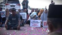 Warga Rempang usai melakukan prosesi tabur bunga di Jembatan IV Barelang, Batam, mengenang satu tahun tragedi aksi penolakan atas penggusuran paksa warga Rempang. (Foto: Liputan6.com/Ajang Nurdin)