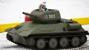 Seorang anak laki-laki mengendarai model tank T-34 era Soviet yang legendaris di objek wisata petualangan anak-anak Tankodrom di taman Sokolniki di Moskow, Rusia (6/1/2020). Model tank ini memiliki mesin pembakaran internal dan kontrol seperti aslinya. (AP Photo/Alexander Zemlianichenko)