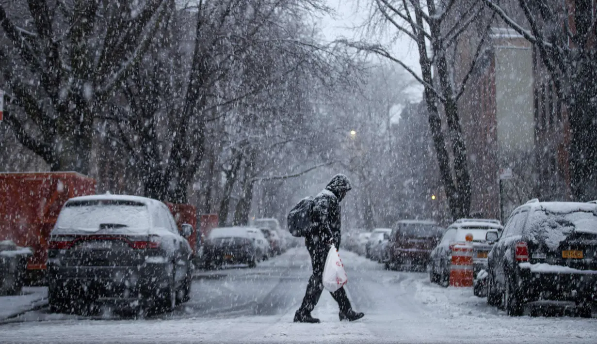 Seorang pria berjalan saat badai salju di Brooklyn di New York City (7/3). Badai salju kedua yang melanda New York dalam waktu seminggu ini diperkirakan akan membawa angin kencang. (Drew Angerer/Getty Images/AFP)