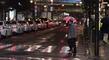 Seorang pria melintasi persimpangan menuju stasiun kereta api di Tokyo, Jumat (5/3/2021).  PM Jepang Yoshihide Suga mengumumkan bahwa pemerintahnya memperpanjang keadaan darurat di wilayah Tokyo selama dua minggu lagi untuk mencegah terjadinya lonjakan infeksi COVID-19. (AP Photo/Hiro Komae)