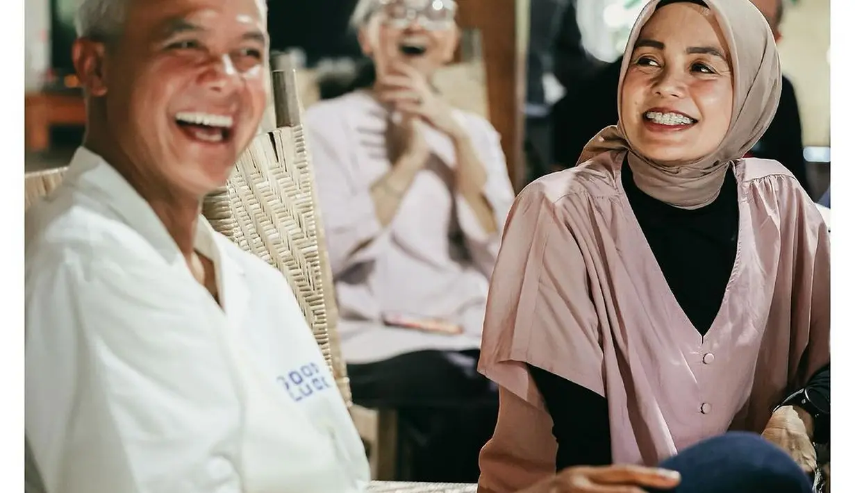 Potret manis Ganjar Pranowo bersama sang istri Siti Atiqoh. Ganjar mengenakan kemeja putih lengan pendek dengan celana panjang hitam, sedangkan Siti Atiqoh terlihat duduk di sebelahnya mengenakan inner hitam dan blouse cokelat, yang serasi dengan hijab polosnya. [Foto: Instagram/ganjar_pranowo]