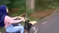 Viral di media sosial, seorang wanita terlihat sedang mengendarai motor dengan menggunakan setir mobil. (@agoez_bandz4).