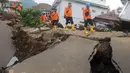 Petugas melintas di jalan yang rusak  pascagempa bumi magnitudo 5,6 di Kampung Cisarua, Desa Sarampad, Kabupaten Cianjur, Jawa Barat, Rabu (23/11/2022). Berdasarkan data BNPB sebanyak 58.362 warga mengungsi akibat gempa bumi di Kabupaten Cianjur tersebut. (merdeka.com/Arie Basuki)
