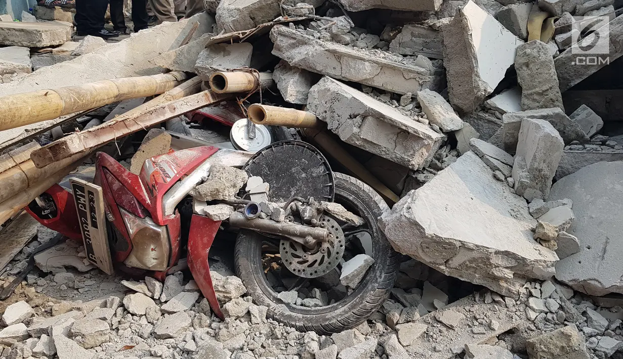 Sebuah motor tertimpa reruntuhan rumah roboh di di  Jalan Pulo, Tanah Tinggi, Johar Baru, Jakarta Pusa, Jumat (26/4). Tiga orang dewasa berhasil dievakuasi, namun masih terdapat 2 ibu-ibu dan 4 anak-anak di dalam rumah tersebut. (Liputan6.com/Herman Zakharia)