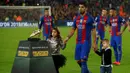 Striker Barcelona, Luis Suarez, didampingi anaknya saat menunjukan Sepatu Emas jelang laga La Liga melawan Granada di Stadion Nou Camp, Spanyol, Sabtu (29/10/2016). Suarez meraih gelar ini usai mencetak 40 gol pada musim lalu. (AFP/Lluis Gene)