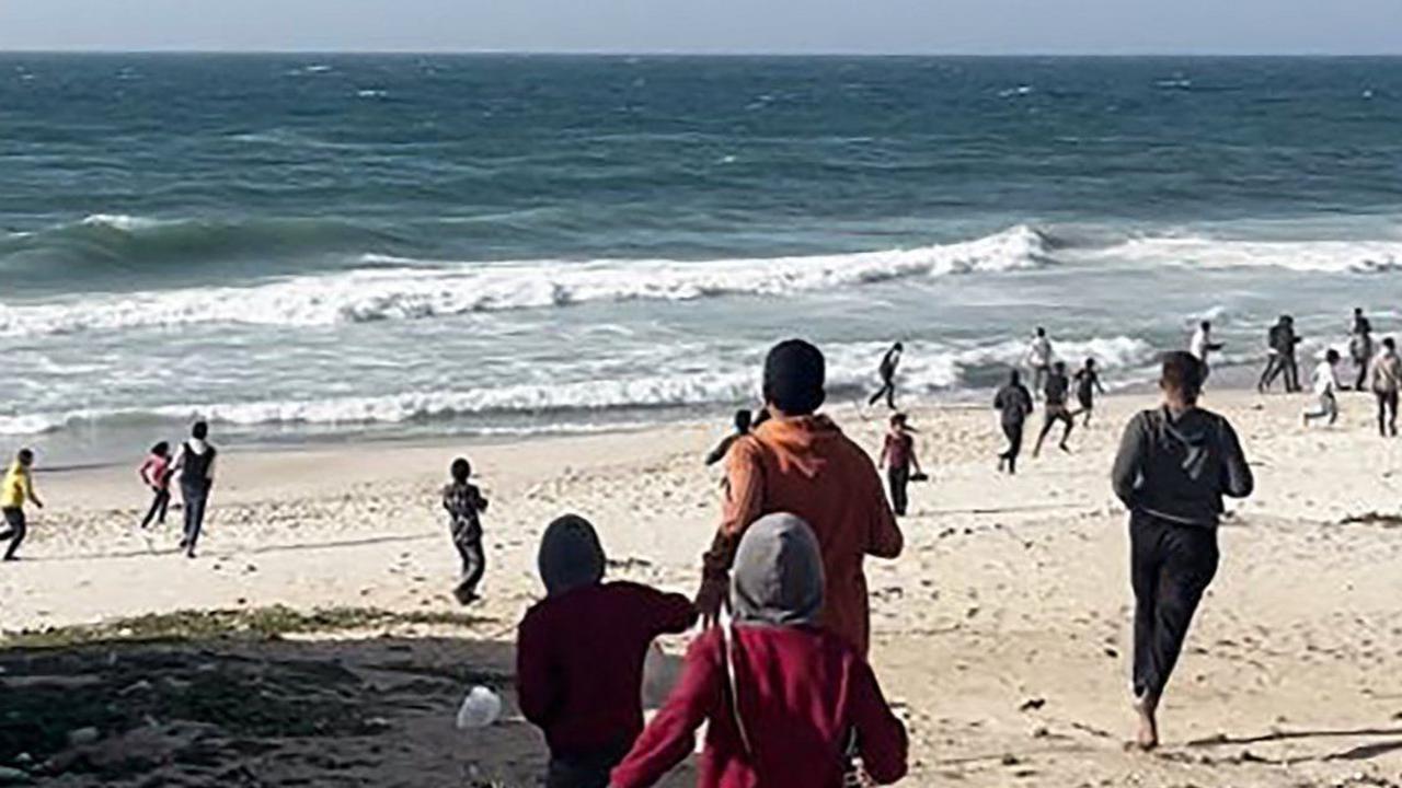 Sejumlah warga berlarian menyambut&nbsp;paket bantuan yang diterjunkan oleh pesawat militer Amerika Serikat di Jalur Gaza, pada Sabtu (2/3/2024).&nbsp;Foto: AFP
