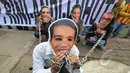 Massa berunjuk rasa dengan memakai topeng bergambar Kepala Staf Kepresidenan Luhut Binsar Panjaitan, Sekretaris Kabinet Andi Widjojanto dan Menteri BUMN Rini Soemarno di depan Gedung KPK, Jakarta, Jumat (6/2/2015). (Liputan6.com/Herman Zakharia)