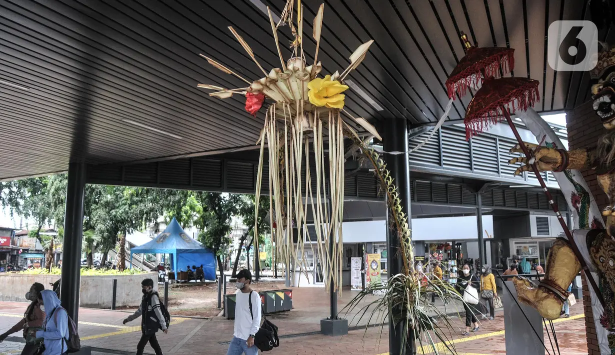 Penumpang Commuter Line atau KRL melintasi patung Ogoh-Ogoh yang dipajang di Stasiun Tebet, Jakarta Selatan, Selasa (1/3/2022). Patung Ogoh-Ogoh tersebut dipajang dalam rangka menyambut Hari Raya Nyepi Tahun Baru Saka 1944 yang jatuh pada 3 Maret mendatang. (merdeka.com/Iqbal S. Nugroho)