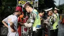 Petugas kepolisian merazia  suporter yang membawa barang berbahaya disekitar kawasan Gelora Bung Karno, Jakarta, Minggu (8/5/2016).Persija akan melawan Semen Padang pada lanjutan Torabika Soccer Championship 2016. (Liputan6.com/Faizal Fanani)