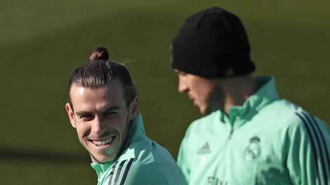 Penyerang Real Madrid, Gareth Bale (kiri) tersenyum saat mengikuti sesi latihan di tempat latihan tim Valdebebas di Madrid, Spanyol (25/11/2019). Real Madrid akan bertanding melawan wakil Prancis, PSG pada Grup A Liga Champions di Santiago Bernabeu. (AP Photo/Manu Fernandez)