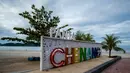 Papan nama Pantai Cenang, tujuan wisata populer di pulau liburan Langkawi, yang ditutup untuk sebagian besar pengunjung luar karena penguncian sebagian yang ditetapkan pihak berwenang untuk mengekang penyebaran Covid-19, di Kedah, Malaysia utara (18/11/2020). (AFP/Mohd Rasfan)