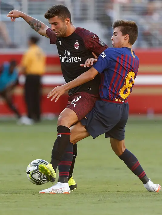 Penyerang AC Milan Patrick Cutrone berusaha melewati pemain Barcelona Ricky Puig saat bertanding pada ICC 2018 di Levi's Stadium di Santa Clara, California (4/8). Milan menang tipis 1-0 atas Barcelona. (AFP Photo/Lachlan Cunningham)