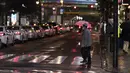 Seorang pria melintasi persimpangan menuju stasiun kereta api di Tokyo, Jumat (5/3/2021).  PM Jepang Yoshihide Suga mengumumkan bahwa pemerintahnya memperpanjang keadaan darurat di wilayah Tokyo selama dua minggu lagi untuk mencegah terjadinya lonjakan infeksi COVID-19. (AP Photo/Hiro Komae)