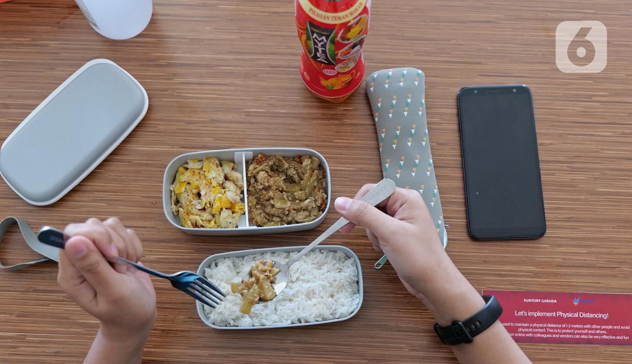 Karyawan menggunakan alat makan pribadi saat menikmati makan siang di ruang istirahat kantor Suntory Garuda, Jakarta, Senin (8/8/2020). Suntory Garuda menerapkan protokol Kesehatan, salah satunya kapasitas karyawan hanya dibolehkan sebanyak 50 persen. (Liputan6.com/Herman Zakharia)