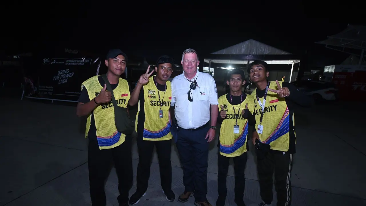 Sekelompok Security Gate sekaligus warga lokal berfoto bersama usai pergantian shift di area Pertamina Grand Prix of Indonesia 2023, pada Jumat (13/10).