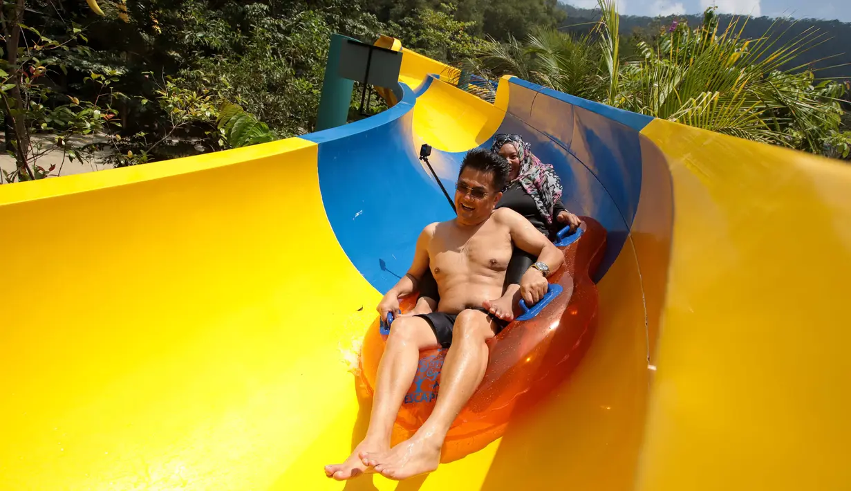 Pengunjung menggunakan pelampung meluncur di perosotan air terpanjang di dunia di Escape theme park di Teluk Bahang, Malaysia (25/9/2019). Perosotan ini mengalahkan perosoton terpanjang yang berada di New Jersey dengan panjang 605m. (AFP Photo/Sadiq Asyraf)