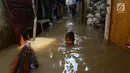 Seorang anak bermain saat banjir merendam permukiman di Kebon Pala, Jatinegara, Jakarta, Selasa (26/2/2019). Banjir karena Sungai Ciliwung meluap akibat air kiriman dari Bogor itu menyebabkan aktivitas warga terganggu. (Merdeka.com/Imam Buhori)