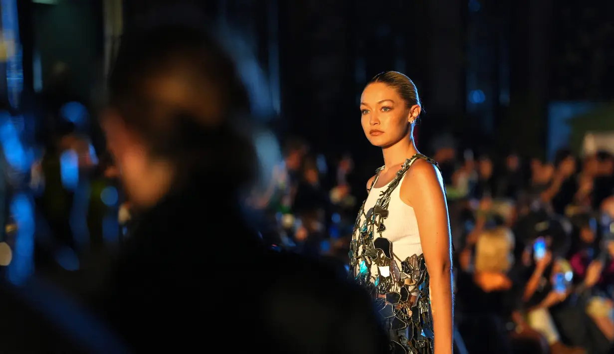 Gigi Hadid berpose saat mengenakan busana VOGUE World: New York selama New York Fashion Week 2022 di New York City (12/9/2022). Gigi juga mengenakan balutan jeans baggy denim dan singlet putih. (Sean Zanni/Getty Images for Vogue/AFP)