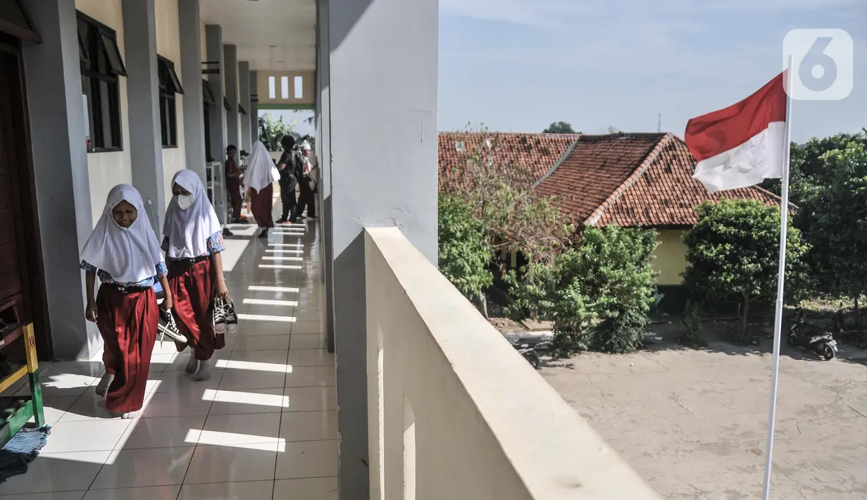 Murid membuka sepatu sebelum memasuki ruang kelas di Sekolah Dasar Negeri (SDN) Mekarsari 05, Tambun Selatan, Kabupaten Bekasi, Jawa Barat, Kamis (28/7/2022). Para guru di SDN Mekarsari 05 berharap pemerintah Kabupaten Bekasi melalui Dinas Pendidikan segera menyediakan meja dan kursi agar lebih layak seperti sekolah pada umummnya. (merdeka.com/Iqbal S. Nugroho)