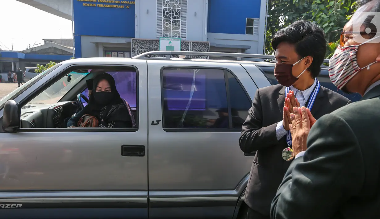 Kepala sekolah dan siswa memberikan salam pada acara Wisuda Pelepasan Kelas XII di Madrasah Aliyah Annajah, Petukangan, Jakarta, Kamis (18/6/2020). Pandemi Covid-19, Madrasah Aliyah Annajah menerapkan Wisuda Drive Thru guna mencegah penyebaran virus Covid-19. (Liputan6.com/Fery Pradolo)