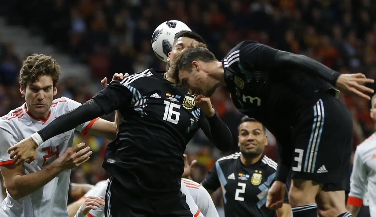 Duel pemain Argentina, Marcos Rojo (tengah) dan pemain Spanyol, Marcos Alonso pada laga uji coba di Wanda Metropolitano stadium, Madrid, (27/3/2018). Spanyol menang telak 6-1 atas Argentina. (AP/Francisco Seco)