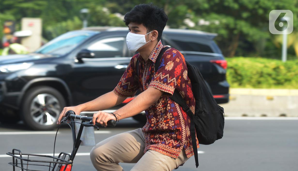 Seorang pria yang mengenakan baju batik bersepeda di kawasan Thamrin Sudirman, Jakarta, Jumat (2/10/2020). Pada Hari Batik Nasional yang berlangsung di tengah pandemi COVID-19, sebagian masyarakat terlihat mengenakan baju dan masker dengan motif batik. (merdeka.com/Imam Buhori)